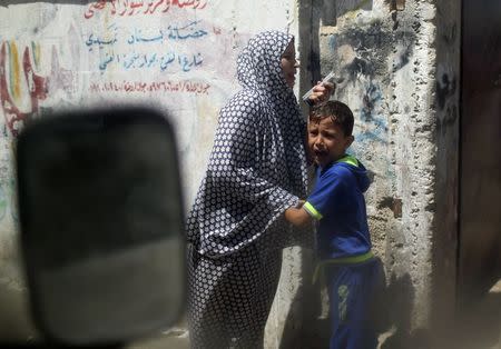 Palestinians fleeing from their houses are pictured through a car window as they react at the scene of what witnesses said was an Israeli air strike in Gaza City August 21, 2014. REUTERS/Mohammed Salem