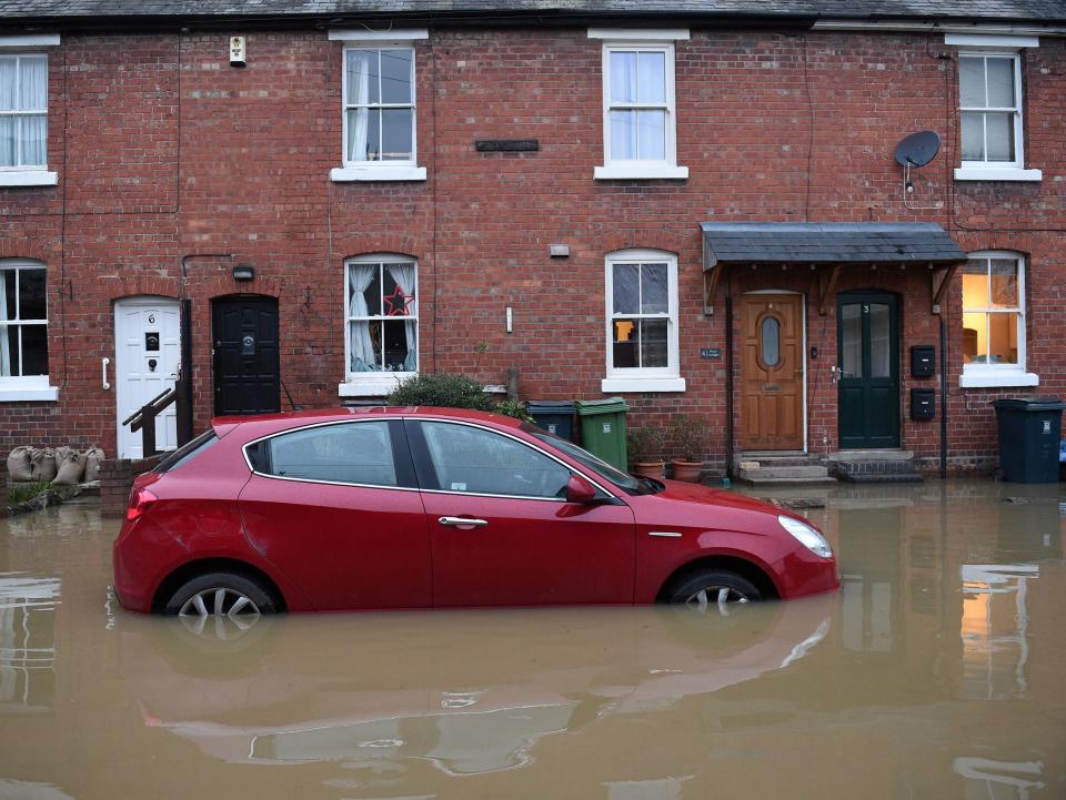 Floodwaters surrounds a car parked outside a row of houses in Shrewsbury, western England, on 22 January 2021 after Storm Christoph brought heavy rains and flooding across the country (Oli Scarff/AFP/Getty)