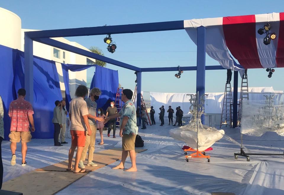 Palmer Luckey (barefoot and wearing Hawaiian shirt) greets people on the empty lot next to his house on Saturday.