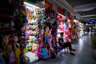 A man sits outside a stall that sells toy products at the Yiwu Wholesale Market following an outbreak of the novel coronavirus disease (COVID-19), in Yiwu