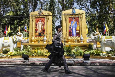 A policeman carries protective gear as he walks next to the residential house of Prem Tinsulanonda, chief of the Privy Council and the king's advisor, in Bangkok January 24, 2014. REUTERS/Nir Elias