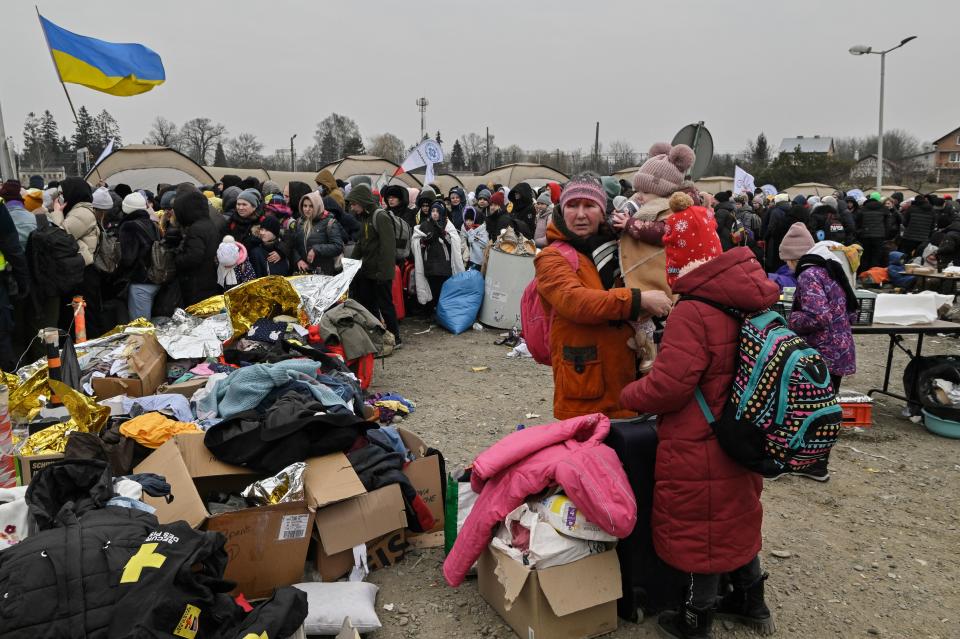 Hundreds of refugees stand in line as they wait to be transferred after crossing the Ukrainian border into Poland, at the Medyka border crossing in Poland, on March 7, 2022. - More than 1.5 million people have fled Ukraine since the start of the Russian invasion, according to the latest UN data on March 6, 2022. (Photo by Louisa GOULIAMAKI / AFP) (Photo by LOUISA GOULIAMAKI/AFP via Getty Images)