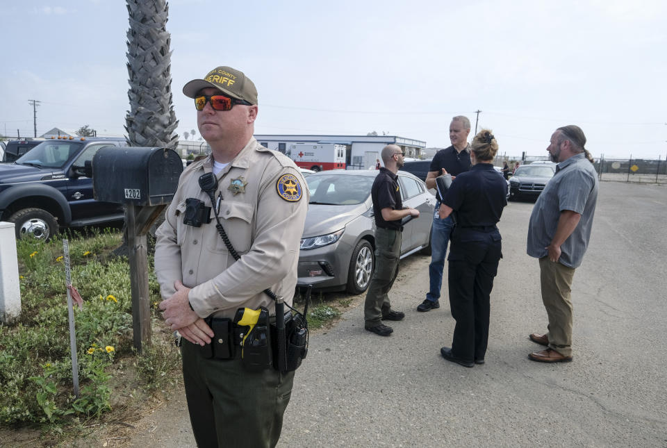 A Ventura County Sheriff's deputy stands guard outside of the U.S. Coast Guard Station Channel Islands in Oxnard, Calif., Sunday, Sept. 2, 2019. (AP Photo/Ringo H.W. Chiu)