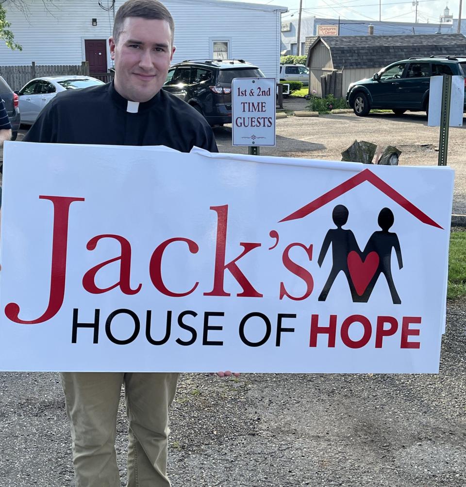 Pastor Joe Svancara, president of the board for Friends of the Homeless of Tuscarawas County, holds the logo for the new Jack's House of Hope shelter during a groundbreaking ceremony Thursday.