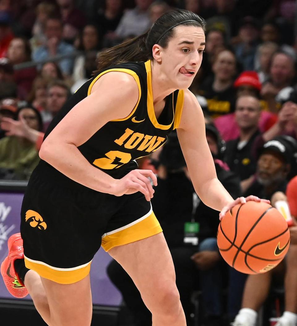 Iowa’s Caitlin Clark bites down on her tongue as she begins to push the ball inside against Virginia Tech during first-half action on Thursday, November 9, 2023 at Spectrum Center in Charlotte, NC.
