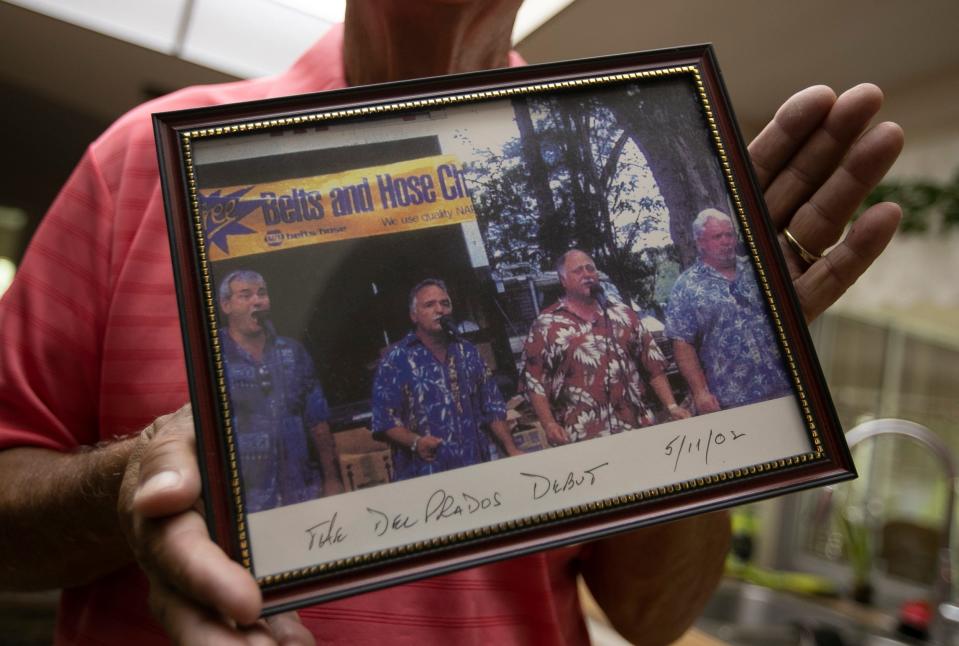 Lou Reyes holds a photo from the first performance by The Del Prados at Lakes Park in Fort Myers, May 11, 2002.