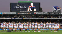 Adelaide players look on as Walsh is honoured.