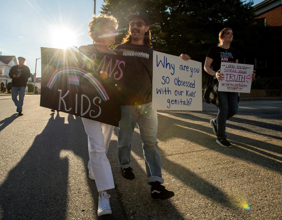 Susan D’Orazio and Matt Villavicencio walk with a group of protesters Wednesday in front of the Diocese of Worcester Chancery building.