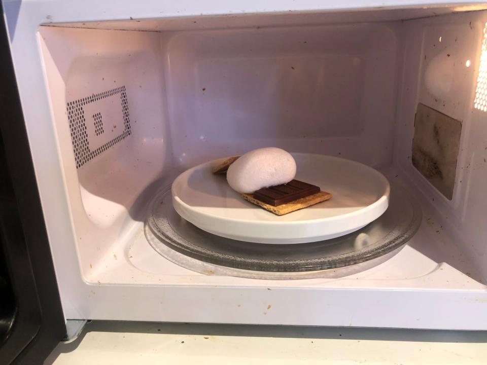 smore toppled over in a microwave with graham crackers and chocolate