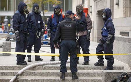 Police officers wearing gas masks stand in the financial district during a mock "crisis response" exercise in Toronto, October 26, 2014. REUTERS/Mark Blinch