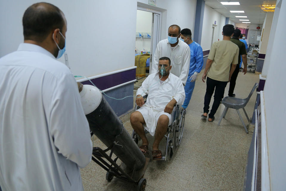 A Coronavirus patient arrives at the hospital in Najaf, Iraq, Wednesday, July 14, 2021. Infections in Iraq have surged to record highs amid a third wave spurred by the more aggressive delta variant, and long-neglected hospitals suffering the effects of decades of war are overwhelmed with severely ill patients. (AP Photo/Anmar Khalil)