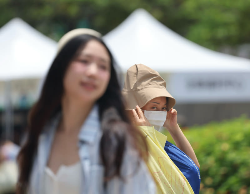 中央氣象署表示，21日天氣各地多雲到晴，高溫可達到攝氏30度以上，南部7縣市要注意36度以上高溫，台東要注意焚風，外出活動請注意做好防曬並多補充水分。圖為台北市中正區民眾外出，戴上帽子遮陽。（中央社）