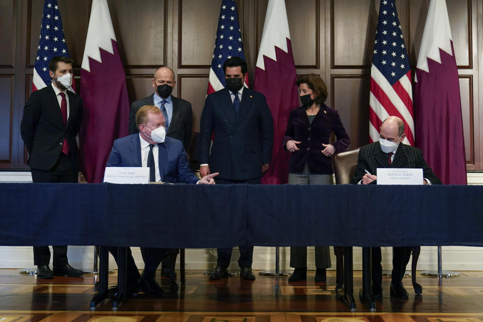 Stan Deal, President and CEO Boeing Commercial Airplanes, left, and Qatar Airways' CEO Akbar al-Baker, right, sign an agreement for the purchase of thirty-four 777-8 Freighter planes with purchase rights for an additional sixteen, in the Eisenhower Executive Office Building on the White House Campus in Washington, Monday, Jan. 31, 2022. Standing behind from left, Brian Deese, Director, National Economic Council, David Calhoun, CEO, The Boeing Company, Qatar's Emir Sheikh Tamim bin Hamad Al Thani and Secretary of Commerce Gina Raimondo. They also signed a letter of intent for an additional purchase from Qatar Airways of twenty-five 737-10s , worth $6.7 billion. (AP Photo/Carolyn Kaster)