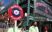 Members of the Boston Red Sox health compliance crew stand at the entrance to Fenway Park before an opening day baseball game between the Red Sox and the Baltimore Orioles, Friday, April 2, 2021, in Boston. (AP Photo/Michael Dwyer)