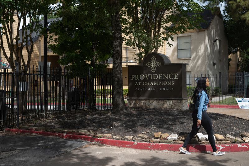 A woman walks out of the Providence at Champions apartment complex in Houston, Texas