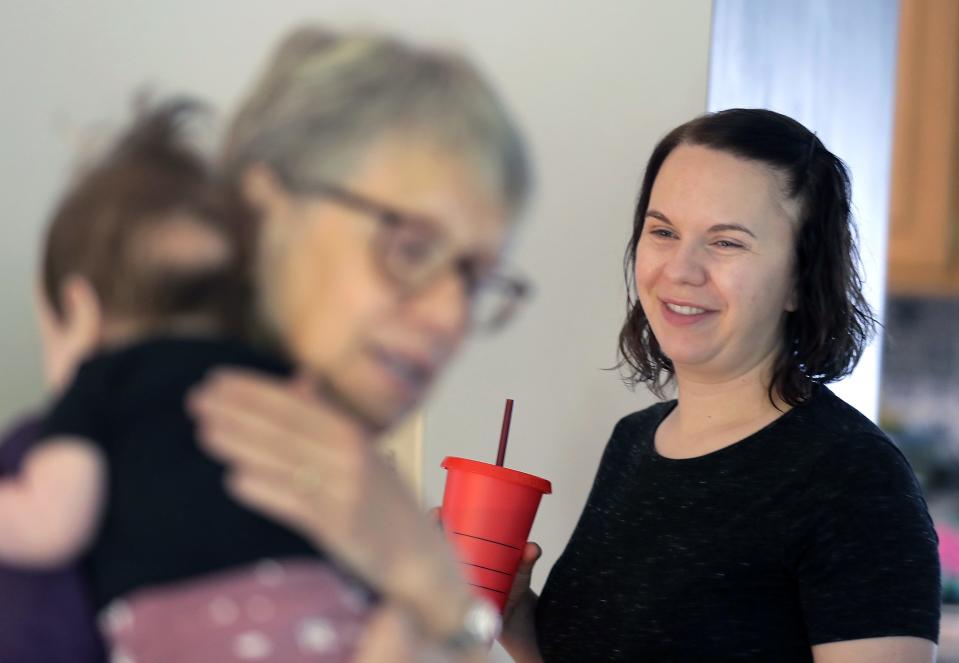 Carolyn Nelson smiles while watching her mom, Gloria Mathews, with her infant daughter, Emma.