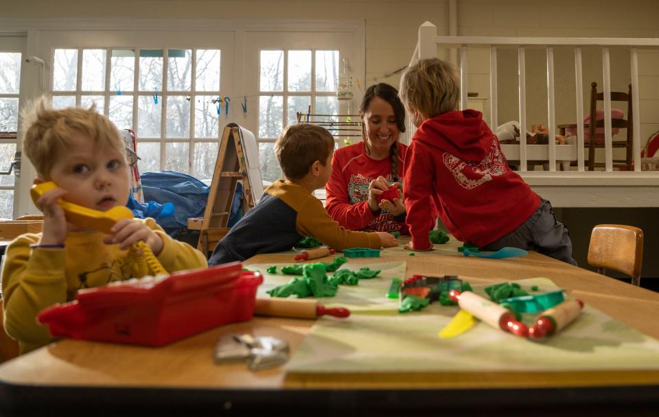 Abby Chipman, a parent volunteer, plays with students Tuesday, Dec. 13, 2022, at the Meridian Hills Cooperative Nursery School & Kindergarten in Indianapolis. 