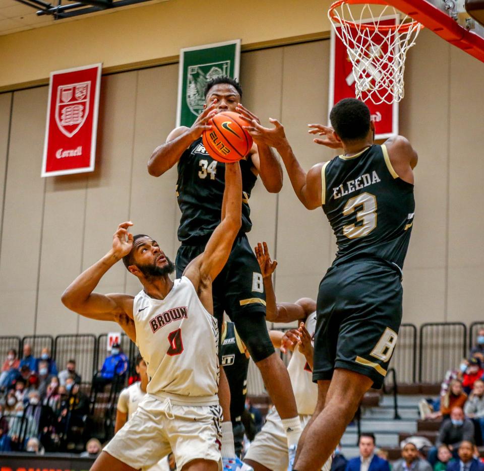 Brown's David Mitchell fights for his own rebound against Bryant's Adham Eleeda and Hall Elisias Friday afternoon.