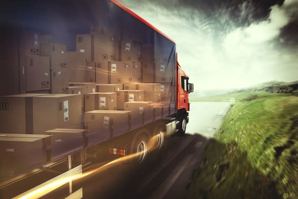 Photo-realistic illustration of a freight truck on highway, with packages exposed through a transparent side panel.