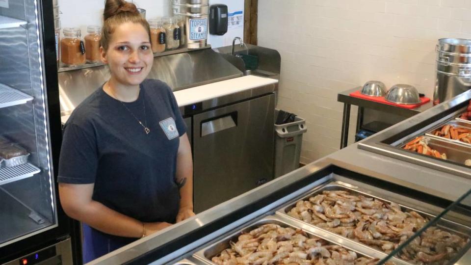 Store manager Tiffany Kaminski is shown 6/15/2023 at the seafood line of Topsail Steamer, 5321 Gulf Drive, Holmes Beach. The new store opened in April.