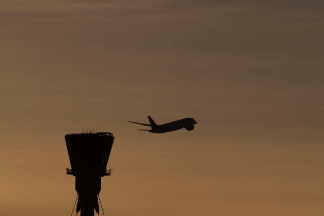 A plane takes off past the control tower at Heathrow Airport (Steve Parsons/PA)