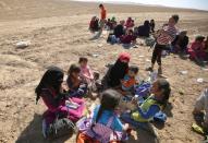 Displaced Iraqi families from the village of Tal al-Shawk on the eastern bank of the Tigris river rest after fleeing their homes as Iraqi government forces launched an assault on the village