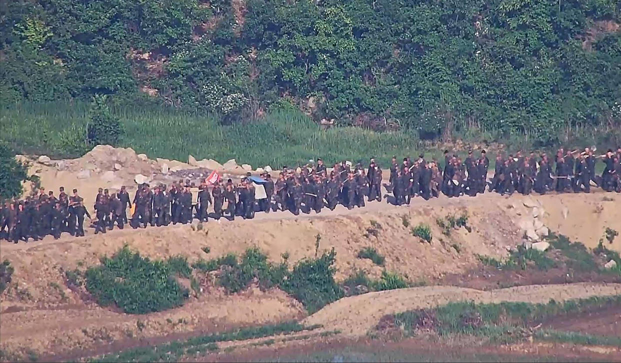 Cette photo non datée, fournie le 18 juin 2024 par le ministère sud-coréen de la Défense, montre des soldats nord-coréens travaillant dans un lieu non divulgué près de la frontière, vus depuis une zone de garde sud-coréenne.