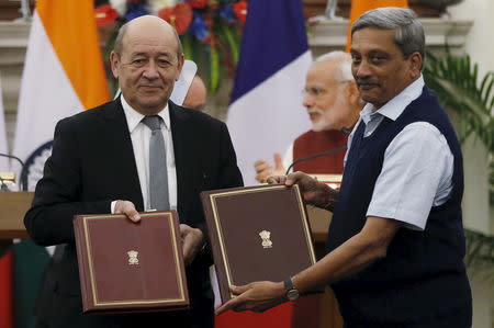 French Defence Minister Jean-Yves Le Drian (L) and his Indian counterpart Manohar Parrikar (R) exchange documents during a signing of agreement at Hyderabad House in New Delhi, January 25, 2016. REUTERS/Adnan Abidi/Files