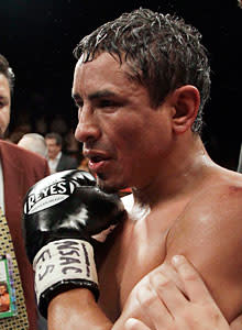 Rafael Marquez holds his injured shoulder after the loss to Juan Manuel Lopez