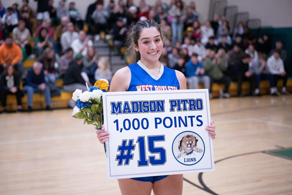 West Boylston's Maddie Pitro poses with her sign after scoring her 1,000th point during the Clinton Holiday Tournament.