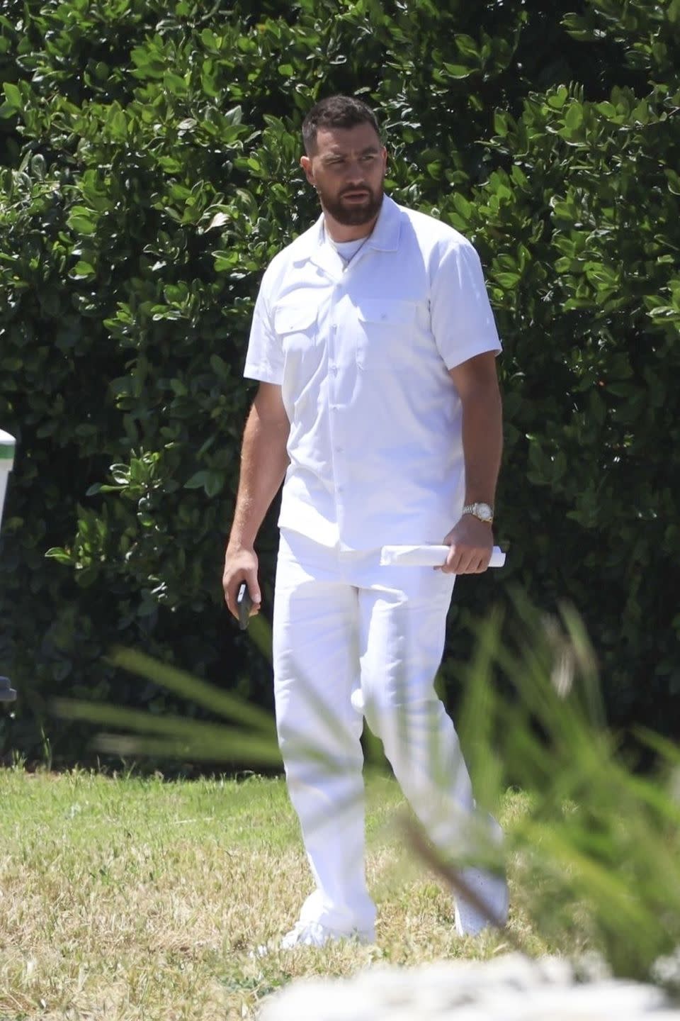 a man standing in front of a bush