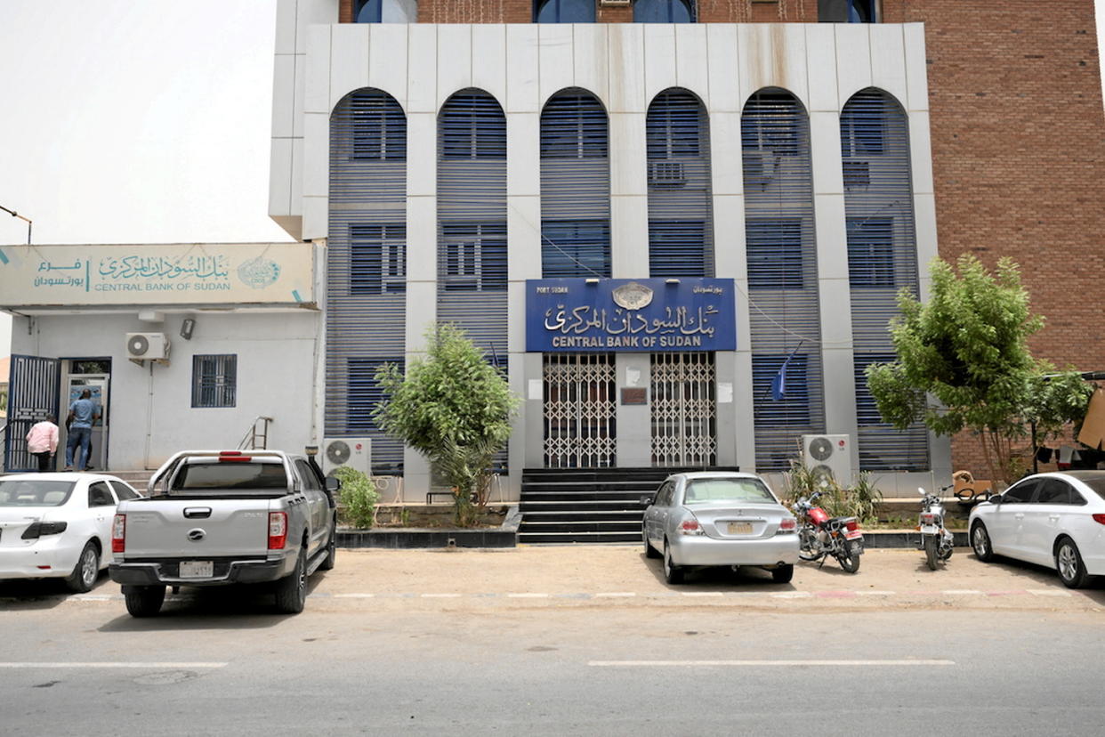 Des Soudanais devant une succursale de la Banque centrale du Soudan, dans la ville de Gedaref, dans l'est du pays, le 9 juillet 2023. De nombreux fonctionnaires soudanais continuent de travailler sans salaire depuis que l'armée soudanaise et les forces paramilitaires de soutien rapide ont pris les armes contre l'un l'autre.   - Credit:- / AFP