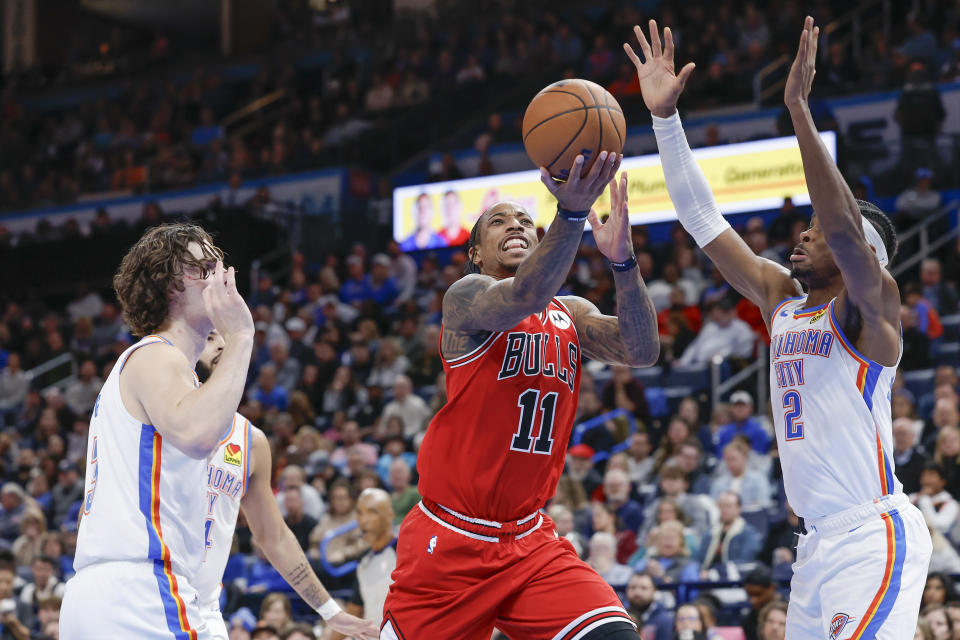 Nov 22, 2023; Oklahoma City, Oklahoma, USA; Chicago Bulls forward DeMar DeRozan (11) drives to the basket between Oklahoma City Thunder guard <a class="link " href="https://sports.yahoo.com/nba/players/6548" data-i13n="sec:content-canvas;subsec:anchor_text;elm:context_link" data-ylk="slk:Josh Giddey;sec:content-canvas;subsec:anchor_text;elm:context_link;itc:0">Josh Giddey</a> (3) and guard Shai Gilgeous-Alexander (2) during the second half at Paycom Center. Mandatory Credit: Alonzo Adams-USA TODAY Sports