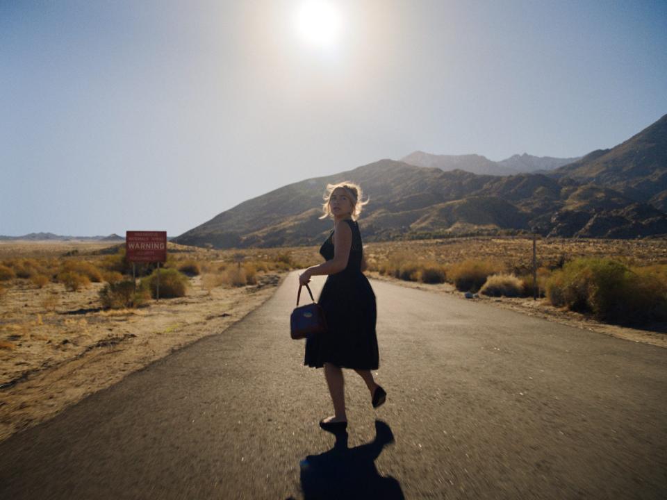 Florence Pugh in a dress running while holding a hand bag