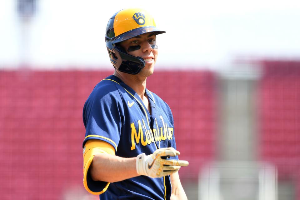 Christian Yelich signals to the dugout after hitting a triple for a cycle in the ninth inning Wednesday afternoon.