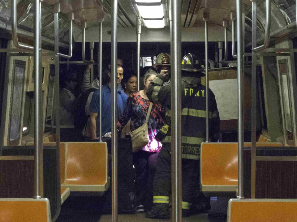 Firefighters instruct passengers on how to exit a subway car after it derailed in the Woodside neighborhood in the Queens borough of New York May 2, 2014. (REUTERS/Connie Wang)