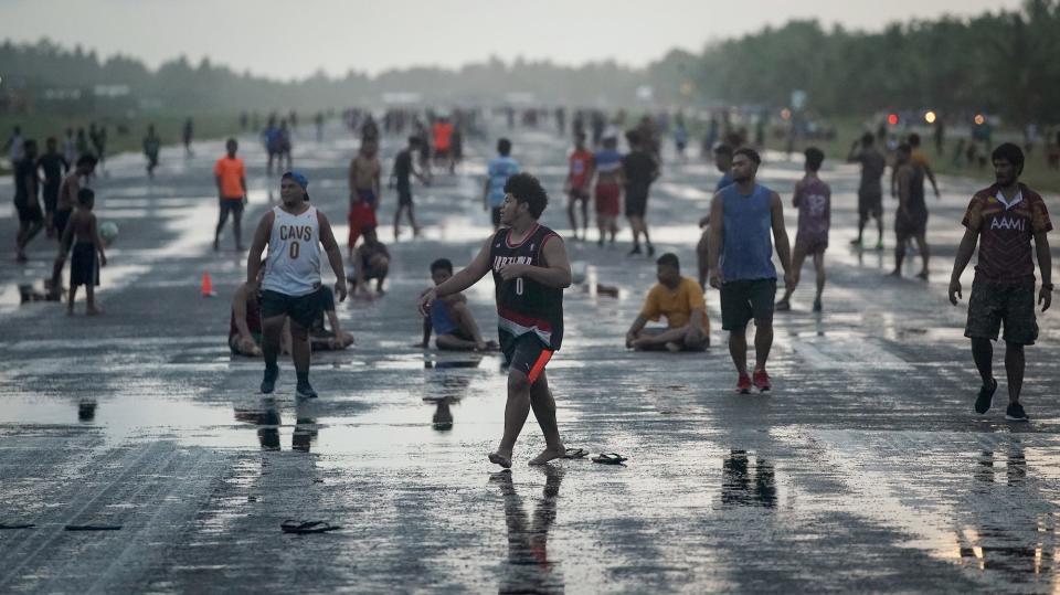 People gather on the airport runway to play sports and socialize on November 25, 2019 in Funafuti, Tuvalu.