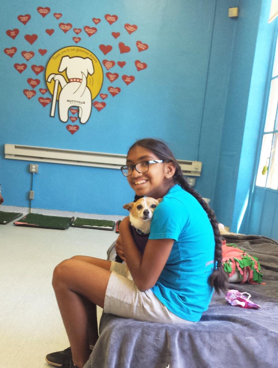 Meena Kumar snuggles a dog at Muttville Senior Dog Rescue. (Photo courtesy of Jayashree Subrahmonia)