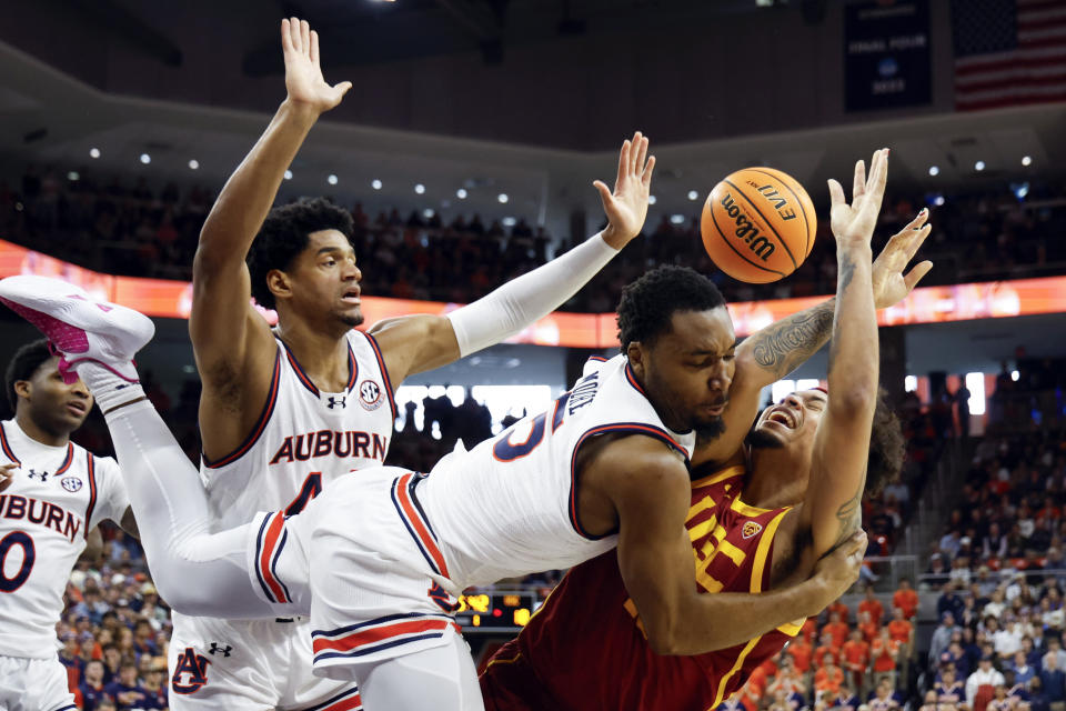 USC forward DJ Rodman (10) is fouled by Auburn forward Chris Moore (5) as he shoots during the first half of an NCAA basketball game, Sunday, Dec. 17, 2023, in Auburn, Ala. (AP Photo/Butch Dill)