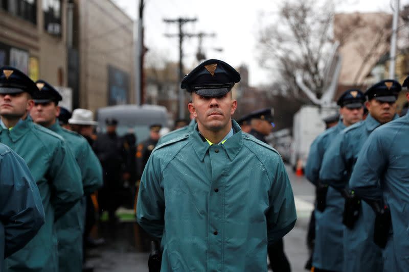 New Jersey State Police officers stand in formation on street ahead of funeral service for Jersey City Police Detective Joseph Seals in Jersey City