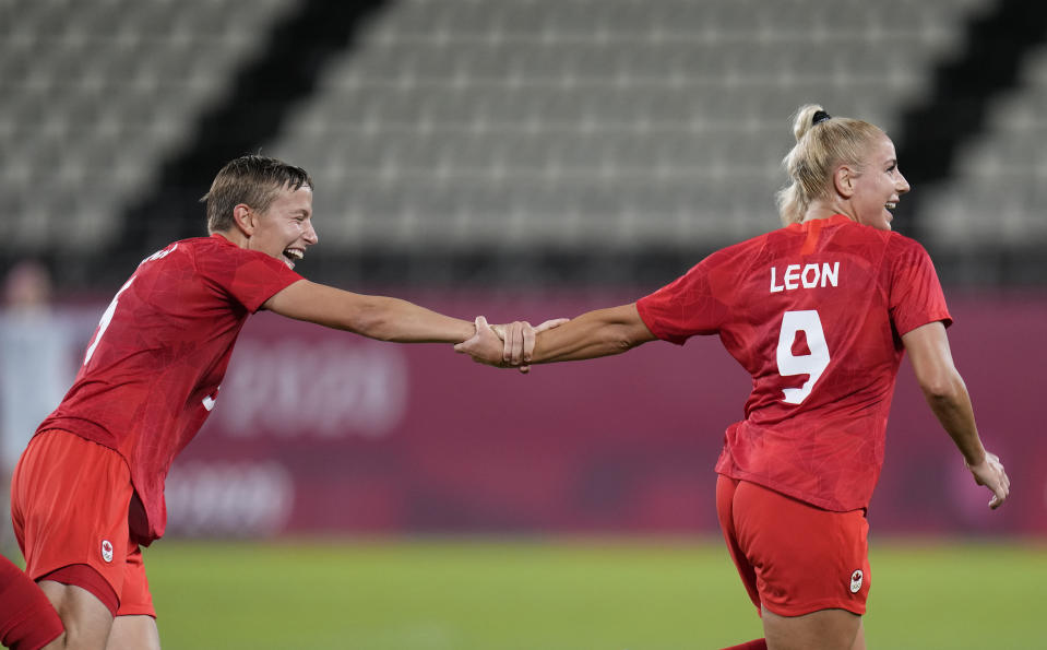 Canada's Adriana Leon, right, celebrates with teammate Quinn after scoring her side's opening goal against Great Britain during a women's soccer match at the 2020 Summer Olympics, Tuesday, July 27, 2021, in Kashima, Japan. (AP Photo/Fernando Vergara)