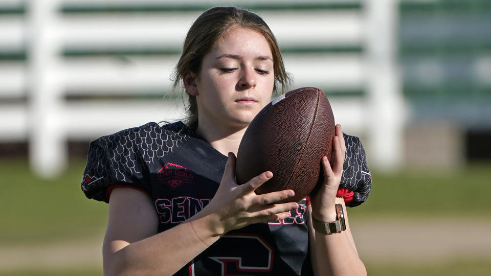 Sam Gordon holds a football, Oct. 20, 2020, in Herriman, Utah. Gordon was the only girl in a tackle football league when she started playing the game at age 9. Now, Gordon hopes she can give girls a chance to play on female-only high school teams through a lawsuit. (AP Photo/Rick Bowmer)