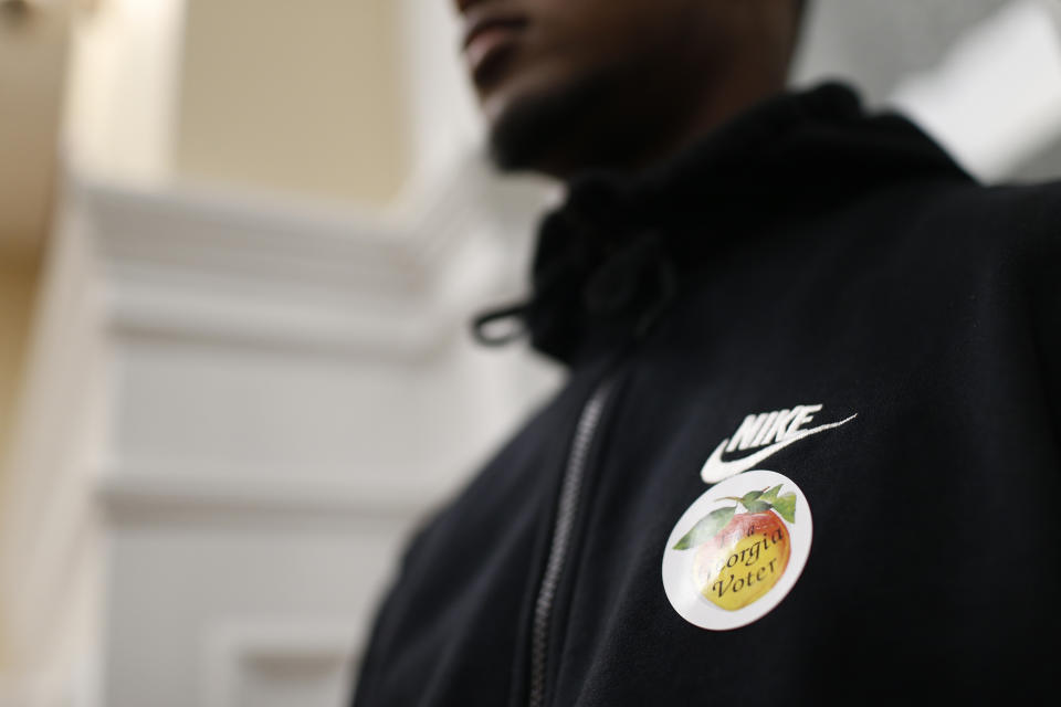 A Cedar Shoals students with an I'm a Georgia voter sticker looks on as fellow students discuss local issues with County Commissioners Mariah Parker and Tim Denson during a field trip to City Hall and the Board of Elections in downtown Athens, Ga., on Wednesday, Oct. 24, 2018. "We've already heard from some students that said 'I didn't know that I could do this I'm going to try to get into politics' and that's one of the big things," Denson said. (Joshua L. Jones/Athens Banner-Herald via AP)