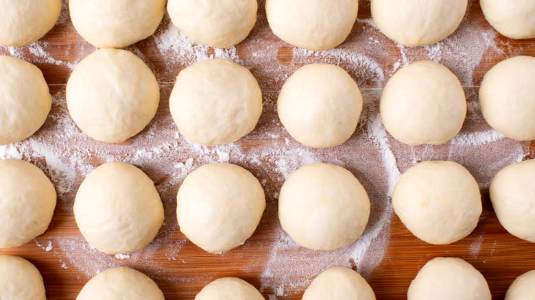 pizza dough balls in grid on floured table