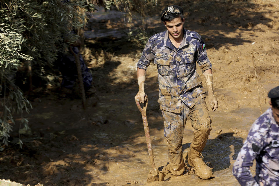 Jordanian rescue teams search Saturday, Nov. 10, 2018 for missing people in the Madaba area, south of the capital of Amman, after flash floods unleashed by heavy rain a day earlier killed at least 12 people. (AP Photo/Raad Adayleh)