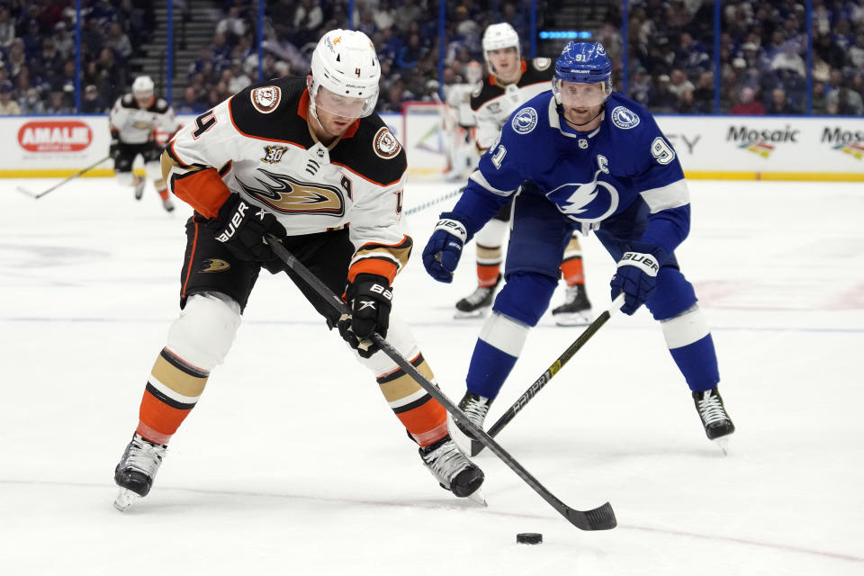 Anaheim Ducks defenseman Cam Fowler (4) carries the puck in front of Tampa Bay Lightning center Steven Stamkos (91) during the first period of an NHL hockey game Saturday, Jan. 13, 2024, in Tampa, Fla. (AP Photo/Chris O'Meara)