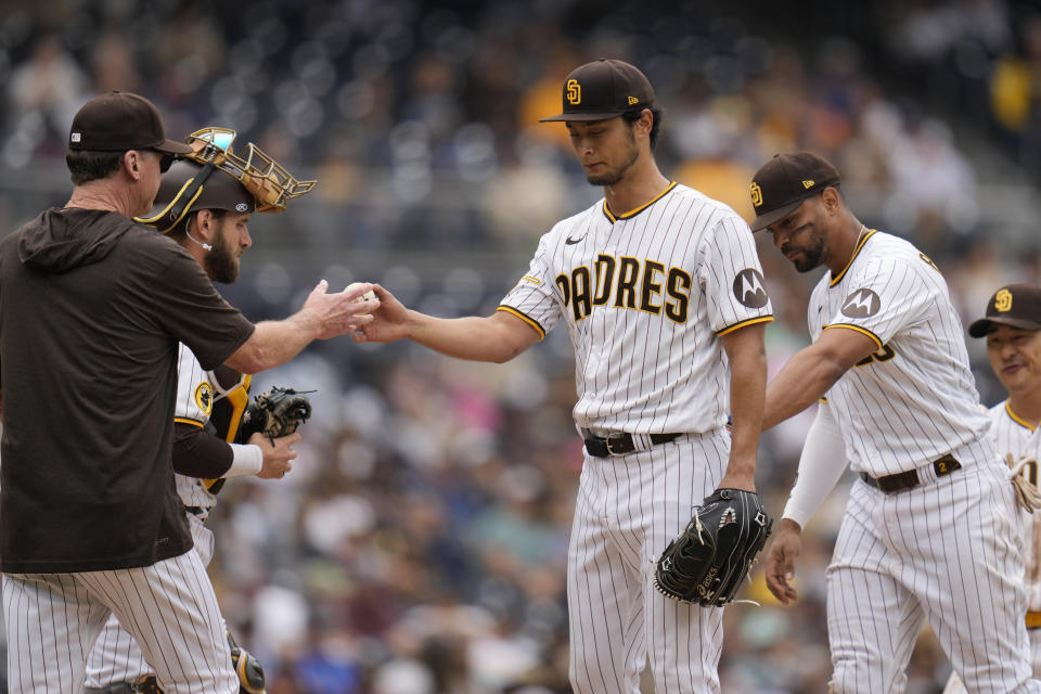 San Diego Padres starting pitcher Yu Darvish, center, hands the ball to manager Bob Melvin as he exits during the sixth inning of a baseball game against the Kansas City Royals, Wednesday, May 17, 2023, in San Diego. (AP Photo/Gregory Bull)