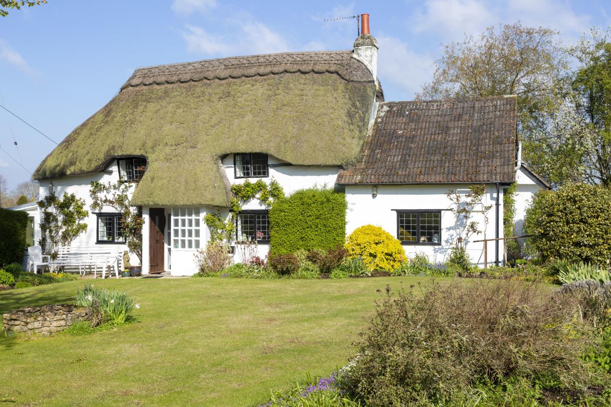 Pretty thatched whitewashed country cottage, Cherhill, Wiltshire, England, UK. (Photo by: Geography Photos/Universal Images Group via Getty Images)