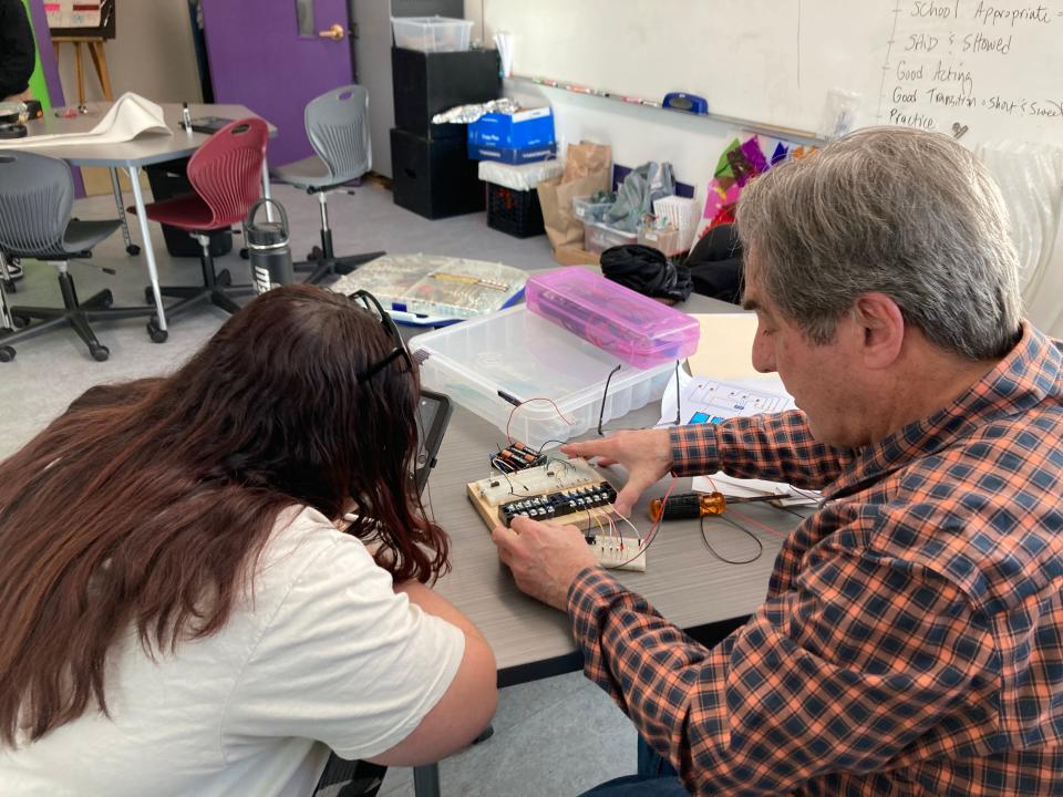 Lia, Grade 8, works with Our Sisters' School community partner, Friends of Buttonwood Park President Richard Leary, on the wiring for one of the light displays in the community light exhibit shown at Buttonwood Park on Feb. 29.