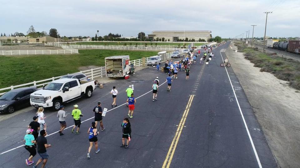 Participants run out on Brink Avenue past Modesto Junior College West campus towards Shoemake Avenue during the Modesto Marathon in Modesto, Calif., on Sunday, March 27, 2022.